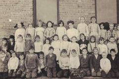 Photograph, First Grade 1911, Garland School Photo of Garland School 1st grade class in 1911.  Bottom row, left to right:  4 Jack Sanders, 5_______ Talley, 6 Harvey Sanders, 7 Raymond Hamilton, 8 Cyril Flook, 9 ________ Willeford, 12 Robert Crossman, 14 Tommy Moss; 2nd row:  Alton Hamilton, 4 ________ White, 5 Mattie Pickett, 6 Mary Lizzie Bell, 7 Nela Weaver, 11 "Deacon" Green.  3rd row:  Lera Pendleton, 2 Hazel Rountree, 3 Betty McCallum, 5 Lola Morrison, 8 Florrie Allen, teacher, 11 Nell Brown, 12 Ruth Halsell, 13 Bennie White.