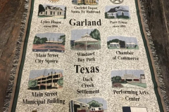A cotton, woven Garland blanket eith green border and fringe depicting local landmarks.