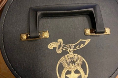 Shriners Fez in black storage case with red interior.
