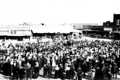 Crowd, northeast corner of square, ca. 1910-11 (per Mike). East and south sides of square visible with crowd. On the south side of square, currently 514 Main St., was Palace of Sweets. Garland News office and City Grocery visible.