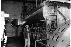 Charles E. Newman, who headed Garland Power and Light from 1923 to 1963, stands beside the new Nordberg generating unit installed in 1955 as the last expansion of the old dieselplant on Avenue A.