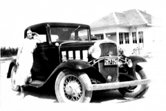 Mabel (Mrs. John Ray) Wynne by automobile in front of Centerville School