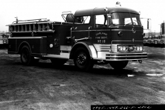 Garland Fire Department Truck No. 18 (GFD designation E-418).  1966 Mack C85, 1000 Gallons per minute, 500 gal).  Location of the truck is at the Mack factory (Ref. L2015.02.E - Photograph of Firefighter at the control panel)