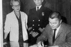 Ernie Wright, Mayor (Seated) signs document Circa 1950's