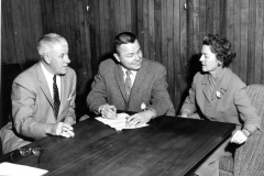 Left to right, Robert McCullough, Ernie Wright, Mayor of Garland, and Mrs. J. W. Nicholson, likely checking plans for the "Mothers' March of Mercy" drive.