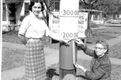 Checking the temperature-reading which records the temperature of the million-dollar Garland Memorial Hospital Campaign are, left to right, Miss Marie Bradshaw, doing the touch-up painting, and Miss Lillian Sammons, who measures to check the audited reading.  Both ladies are working in Campaign Headquarters at 9th and State Streets.