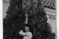 Garland High School cheerleader carrying school band banner 1946