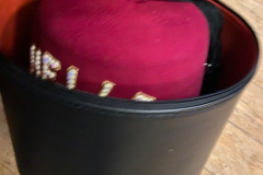 Shriners Fez in black storage case with red interior.