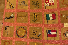 Quilt showing Texas icons and flags with designs by Janie Suter's class