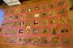 Quilt showing Texas icons and flags with designs by Janie Suter's class