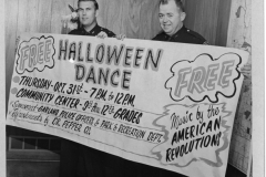 Police officers holding up sign for free Halloween Dance Thursday Oct. 31