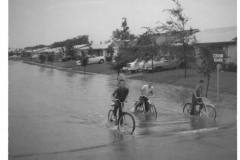 Young boys on bicycles in flood waters, corner of Walnut and Lawson Streets August 1961