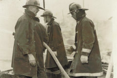 Fire fighters at burning structure, unknown location