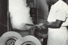 Caption attached reads: Lee and Foley blocking machine with 36 fingers to spread fur felt cone sufficiently to insert crown block. This is the first operation in "finishing" a hat after the fur felt body has been completed. Steam is an essential factor in the shaping and reshaping of fur felt. It is needed in abundencebut since it is also a hazard because of heat intensity it must be kept free from harming workers. V belts are used to exhaust the steam away from this operation and operators.